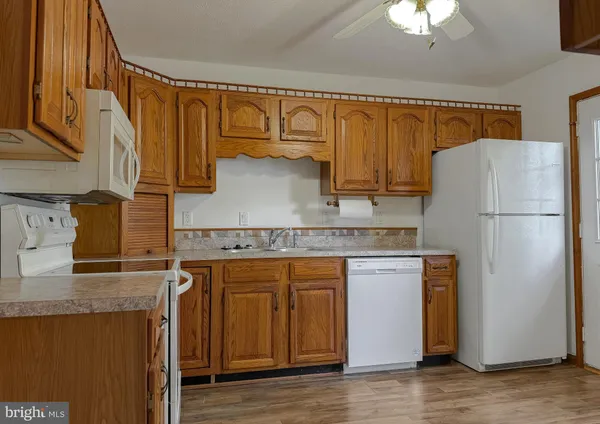 a kitchen with stainless steel appliances granite countertop a refrigerator a stove and a sink