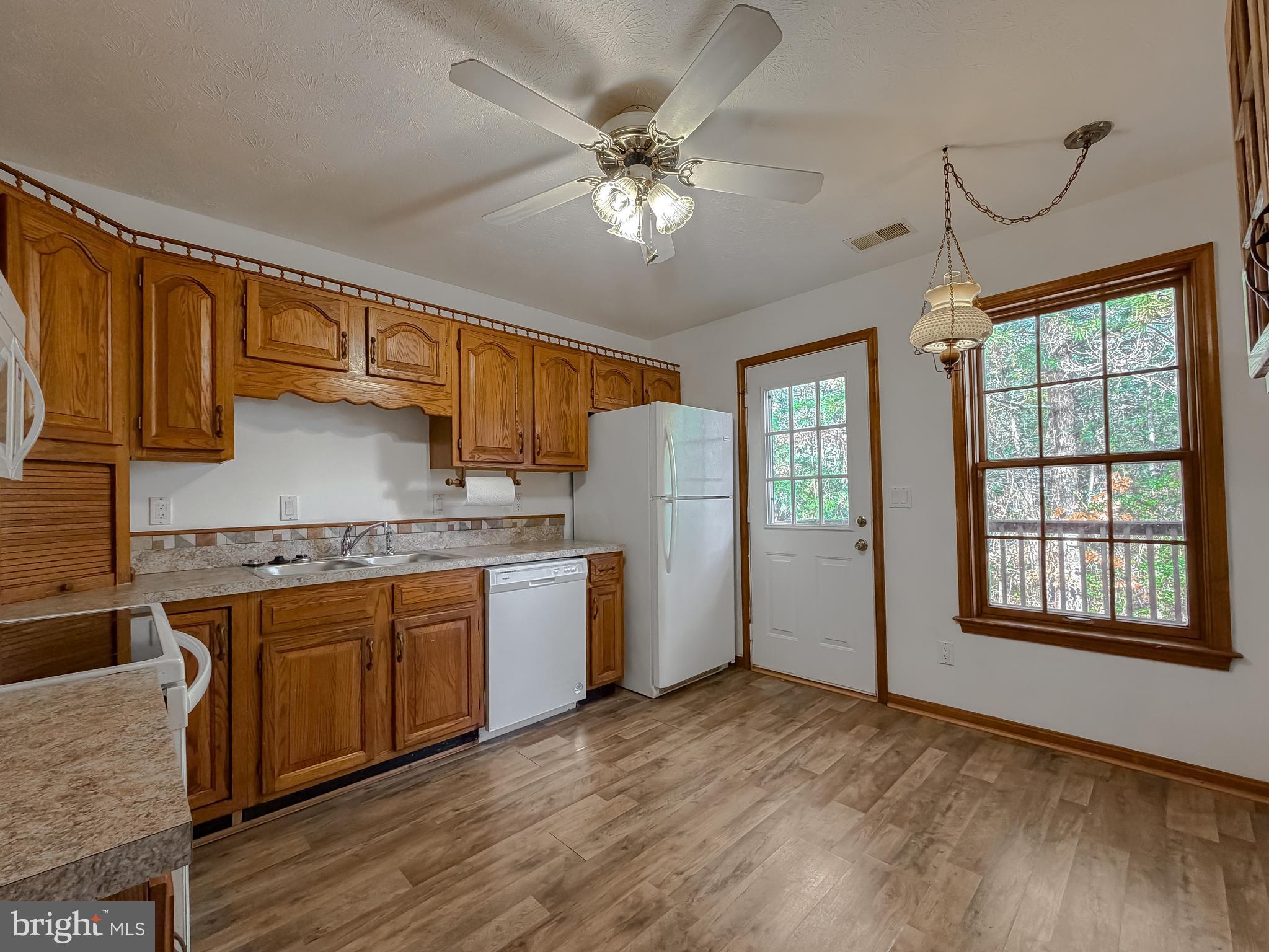 44029 Fieldstone Way California, MD 20619 - Photo 21 of 37 a kitchen with granite countertop a sink cabinets stainless steel appliances and a window