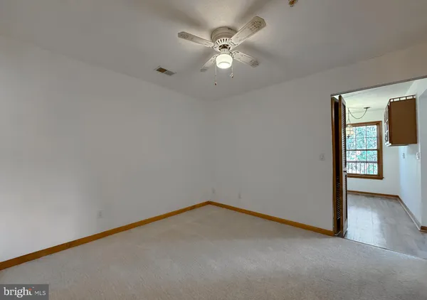 an empty room with fan and windows