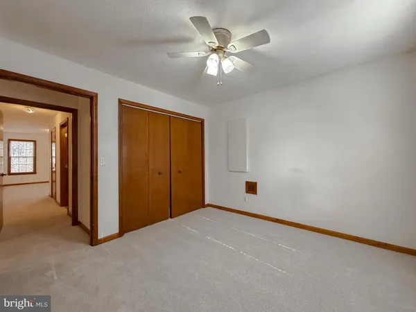 a view of an empty room with chandelier fan