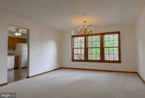 an empty room with chandelier and windows