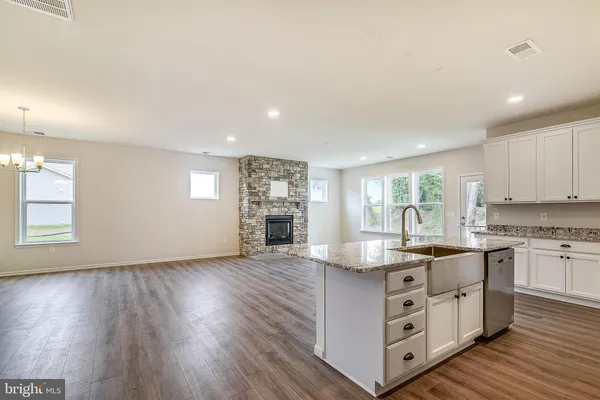 a kitchen with stainless steel appliances granite countertop a sink cabinets and wooden floor