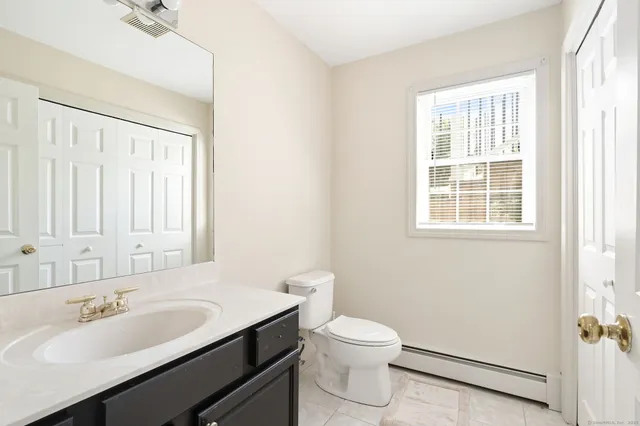 a bathroom with a sink a toilet and a mirror