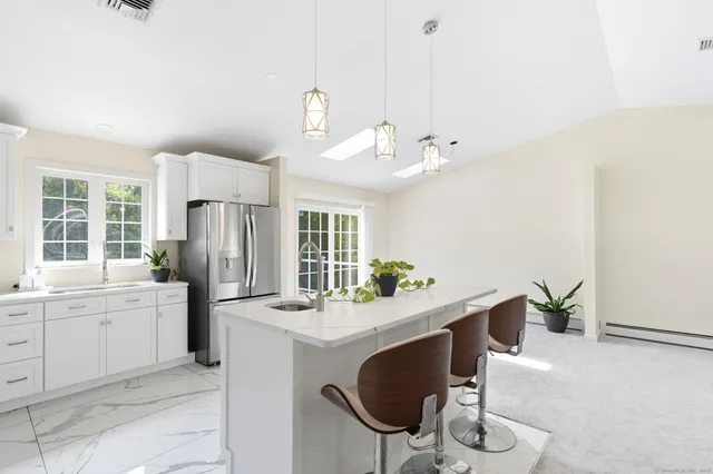 a large kitchen with a stove a kitchen island and stainless steel appliances