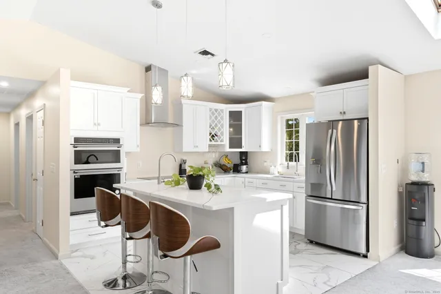 a kitchen with a sink stainless steel appliances and white cabinets