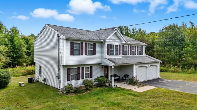 a front view of a house with a yard and trees