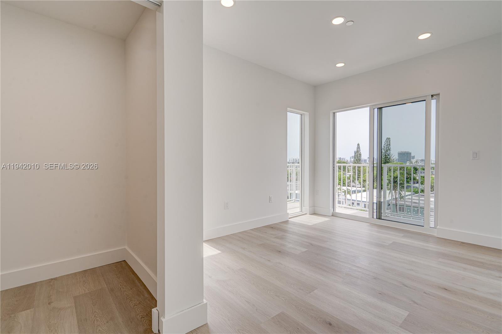 816 84th Street, Unit 2 Miami Beach, FL 33141 - Photo 12 of 19 a view of an empty room with wooden floor and a window