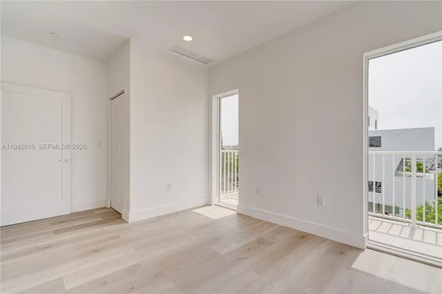 an empty room with an entryway and wooden floor