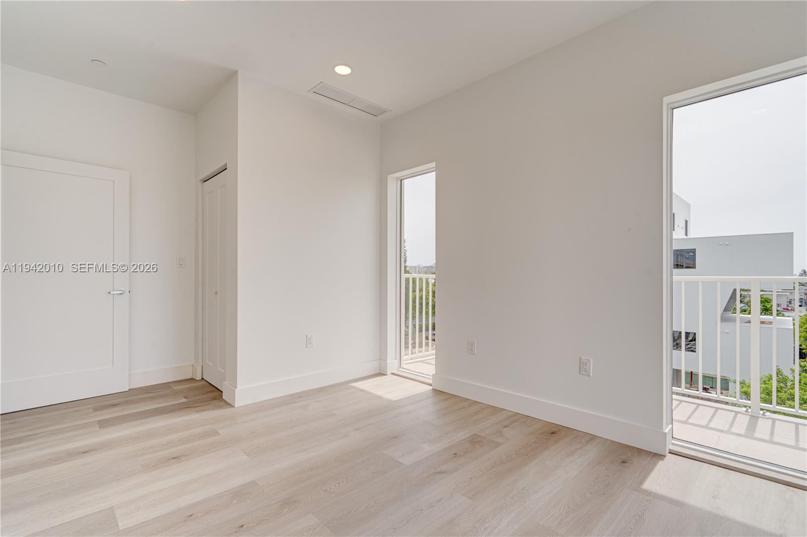 816 84th Street, Unit 2 Miami Beach, FL 33141 - Photo 14 of 19 an empty room with an entryway and wooden floor