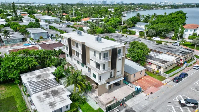 an aerial view of residential houses with outdoor space and parking
