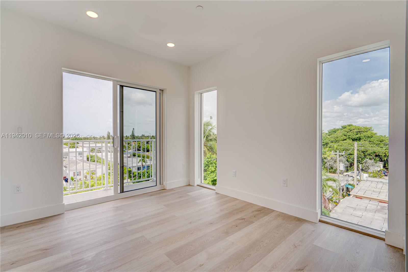 816 84th Street, Unit 2 Miami Beach, FL 33141 - Photo 5 of 19 an empty room with wooden floor and windows