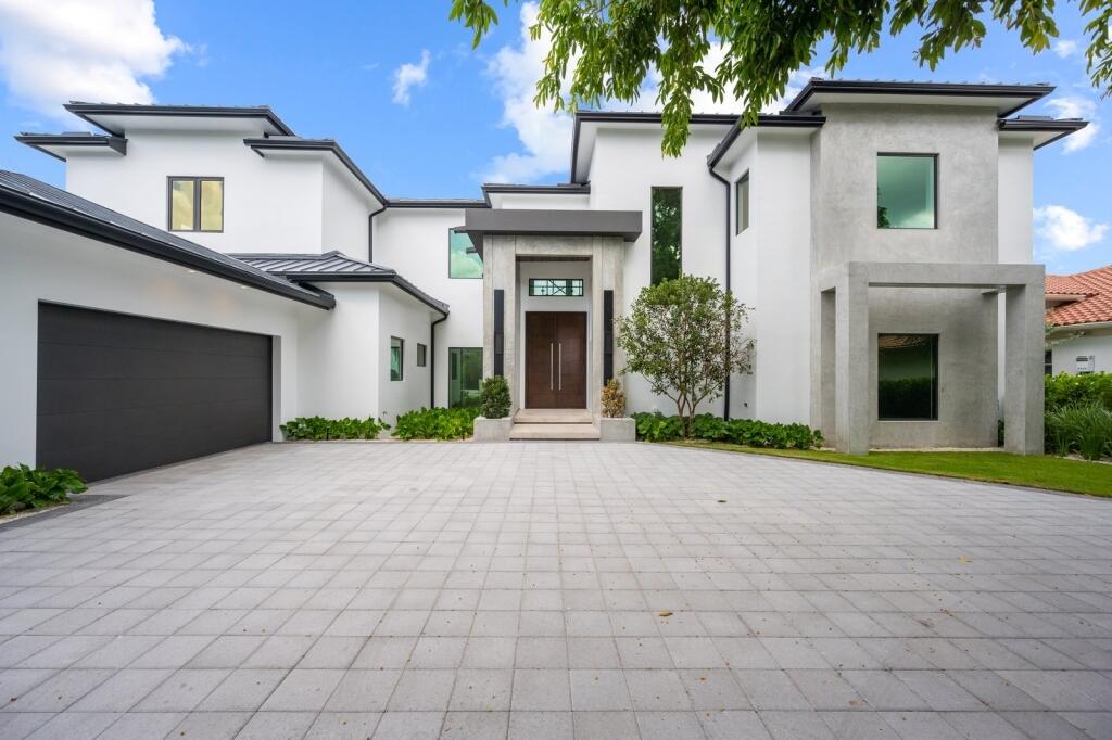 19311 North Riverside Drive Tequesta, FL 33469 - Photo 1 of 31 a front view of a house with garden
