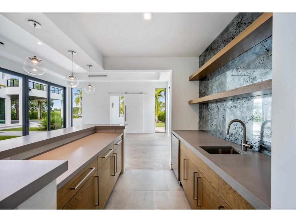19311 North Riverside Drive Tequesta, FL 33469 - Photo 20 of 31 a kitchen with stainless steel appliances a sink a stove and a wooden floor