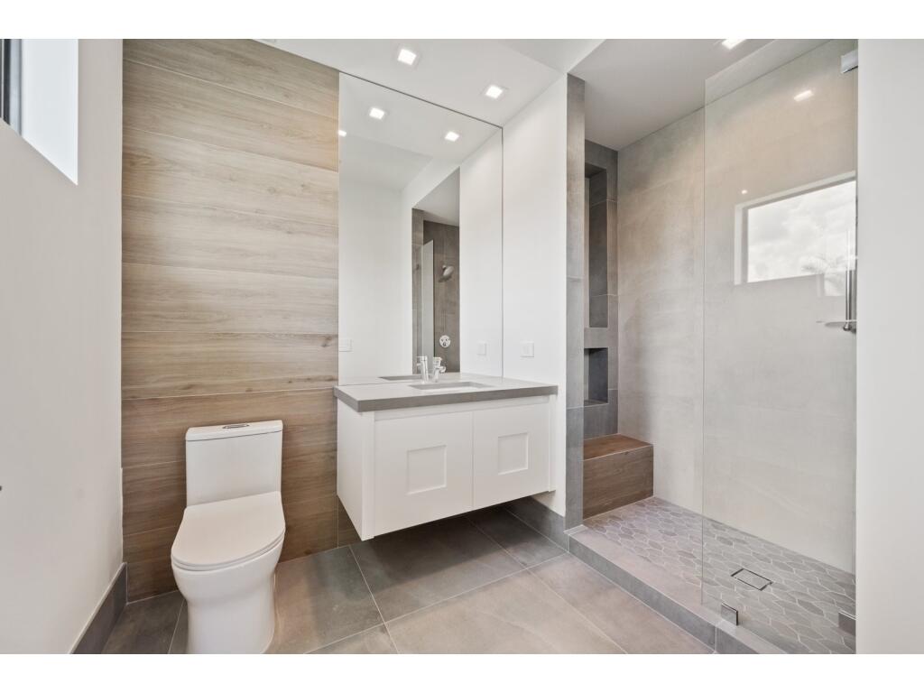 19311 North Riverside Drive Tequesta, FL 33469 - Photo 29 of 31 a bathroom with a toilet a sink and mirror