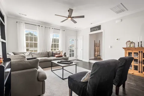 a living room with furniture a ceiling fan and a window