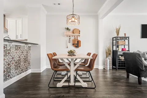 a dining room with furniture a chandelier and wooden floor