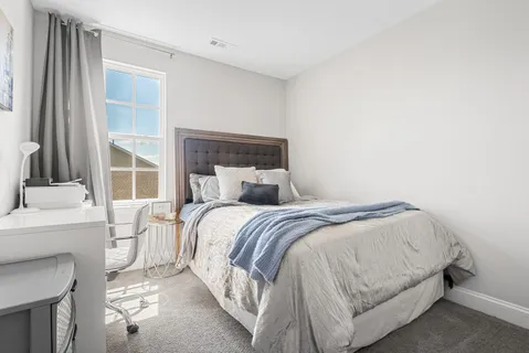 a bed sitting in a bedroom next to a window