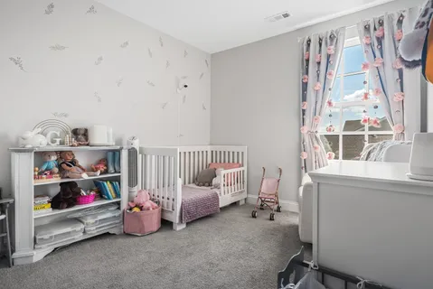 a bedroom with baby toys and a window