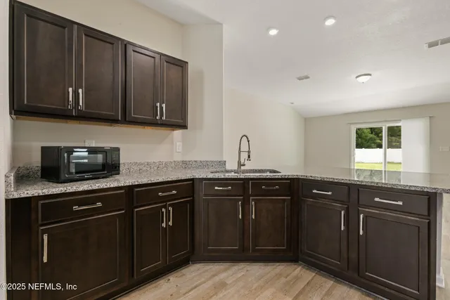 a kitchen with stainless steel appliances granite countertop wooden cabinets and a sink