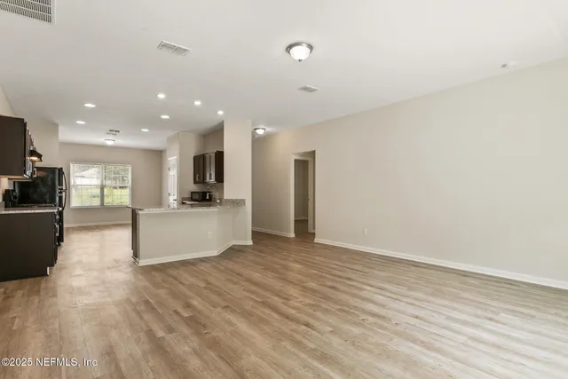 a view of kitchen with refrigerator cabinets and wooden floor