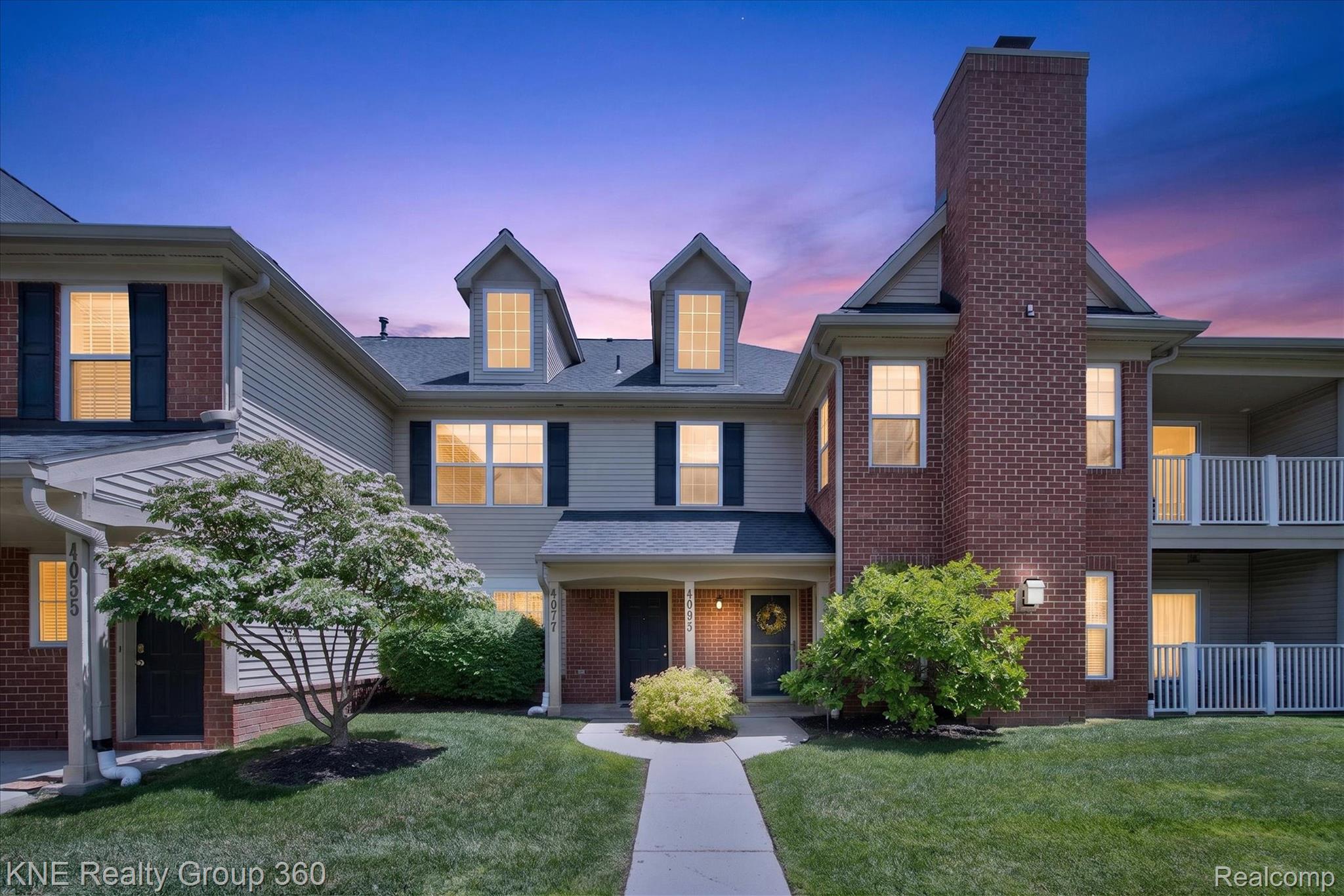 4077 Berkeley Avenue Canton, MI 48188 - Photo 1 of 32 Multi-level townhome exterior featuring light-colored siding, brick accents, multiple dormer windows, and a prominent brick chimney