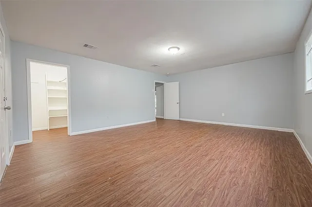 a view of an empty room with wooden floor