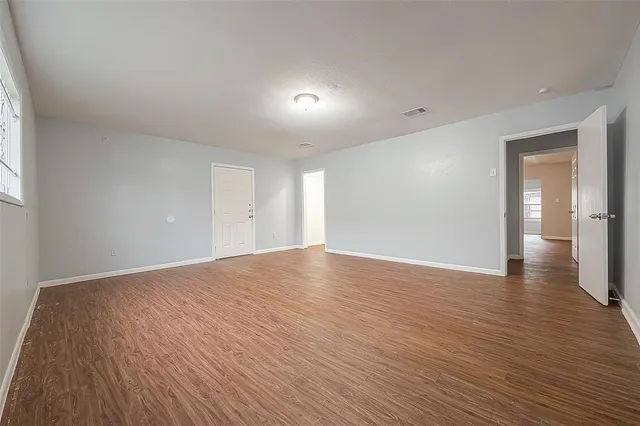 a view of empty room with wooden floor