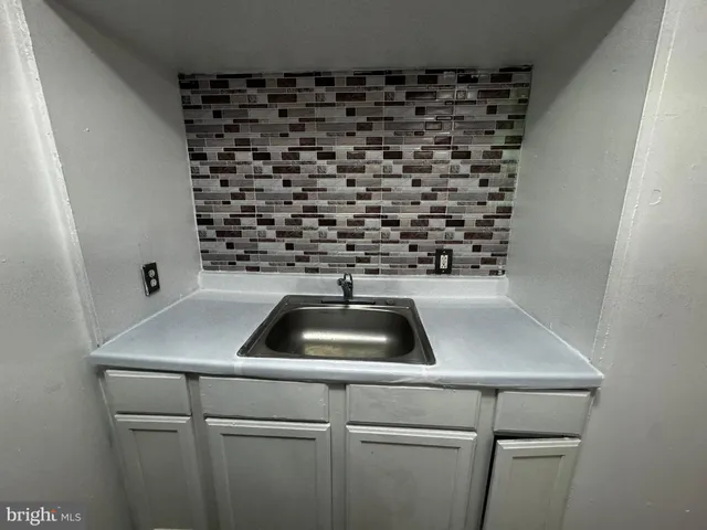 a kitchen with a refrigerator and a stove top oven