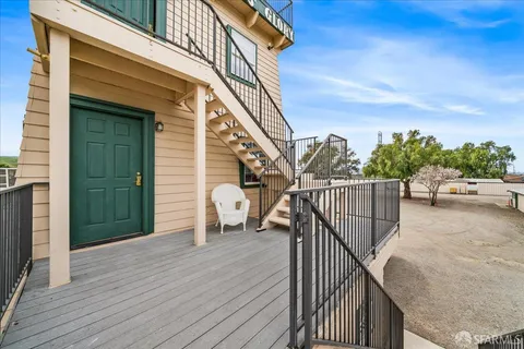 a view of a balcony with wooden floor and stairs