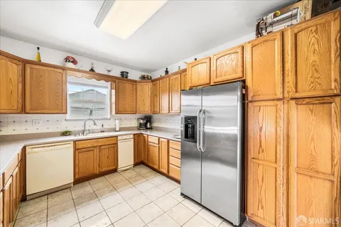 a kitchen with stainless steel appliances granite countertop a refrigerator and a sink
