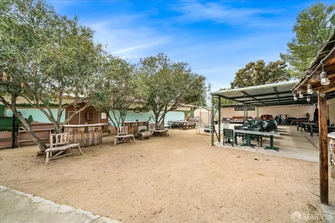 a view of a patio with a table and chairs under an umbrella