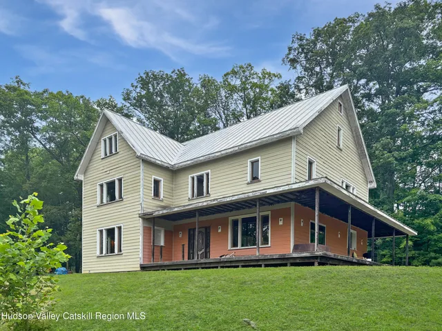 a front view of a house with a garden and trees