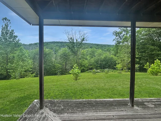 a view of a big house with a big yard and a large trees