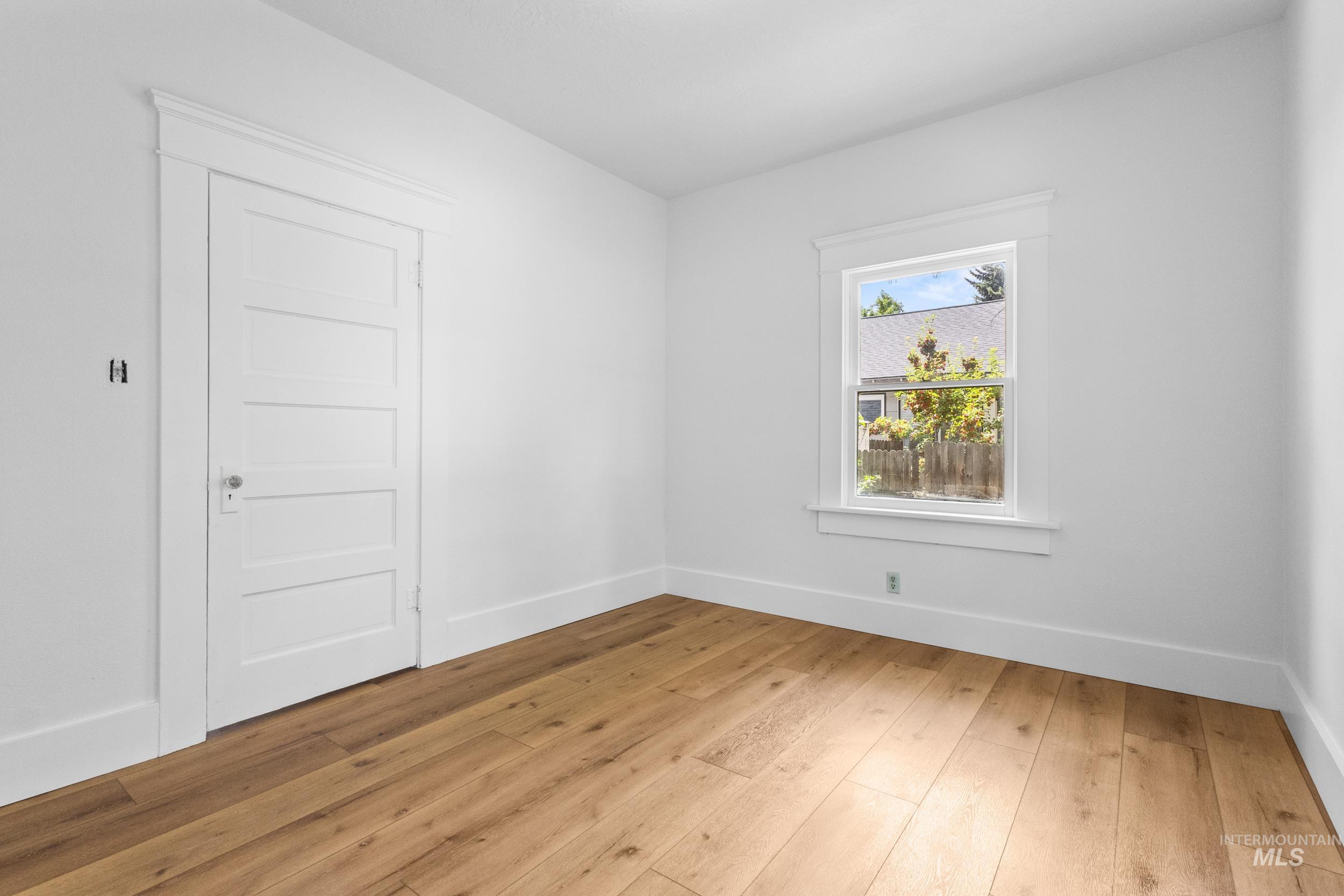 2119 West Brumback Street Boise, ID 83702 - Photo 19 of 30 Bright interior space featuring wood-finish flooring, white walls, and a multi-panel door with white trim