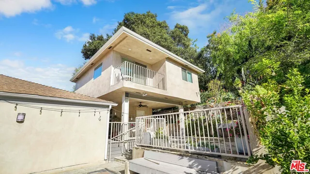 a view of a house with a small yard and wooden fence