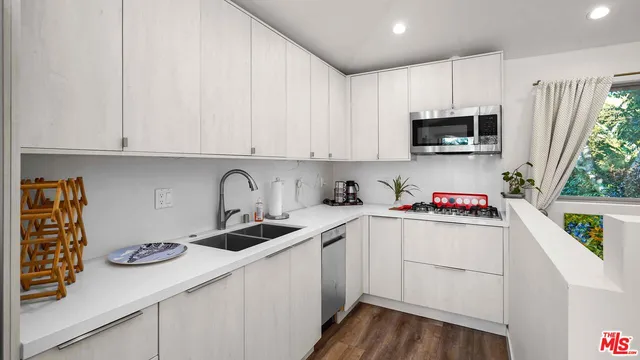 a kitchen with stainless steel appliances granite countertop a sink a stove and cabinets