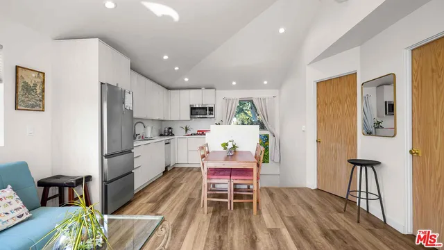 a kitchen with a table chairs refrigerator and a dining table