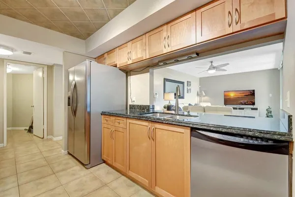 a kitchen with stainless steel appliances granite countertop a refrigerator and a stove