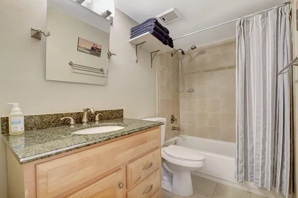 a bathroom with a granite countertop sink toilet and shower