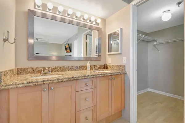 a bathroom with a granite countertop sink and a mirror