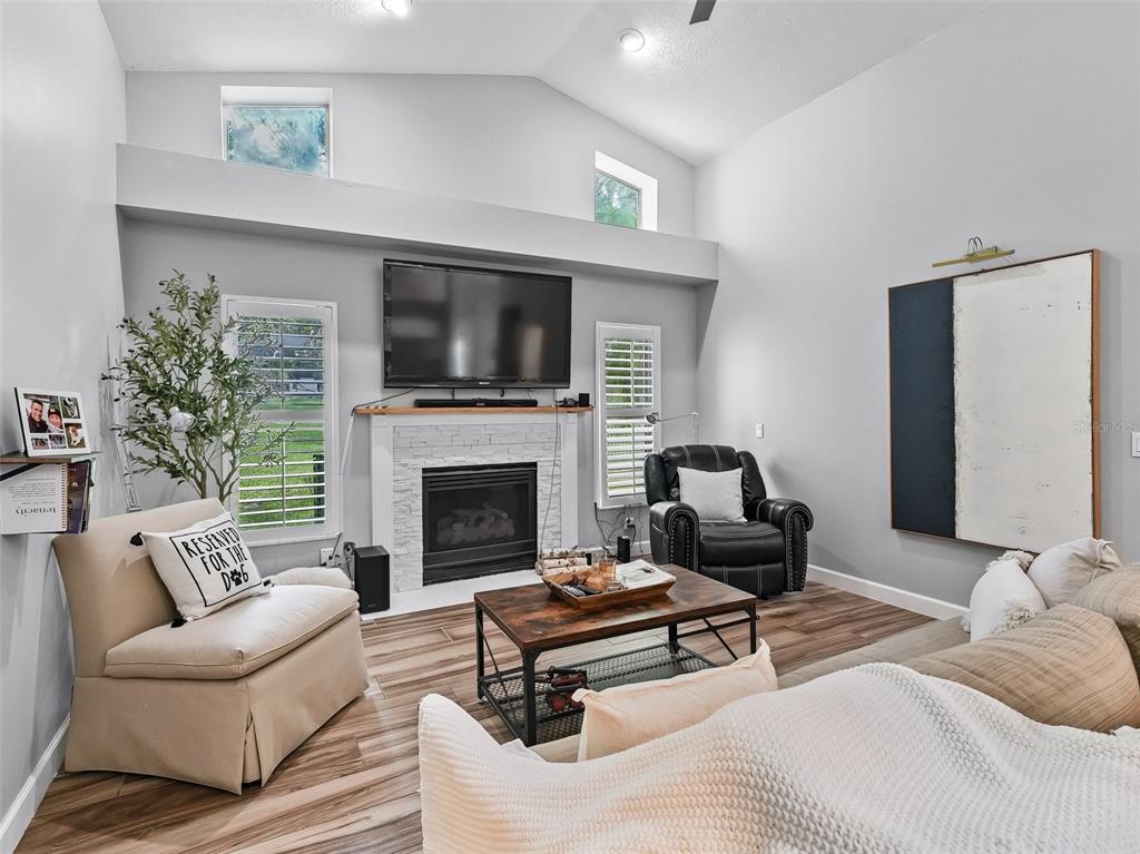 5714 Northwest 80th Ave Road Ocala, FL 34482 - Photo 14 of 39 a living room with furniture a flat screen tv and a fireplace