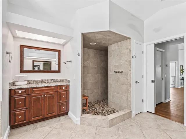 a spacious bathroom with a granite countertop sink and a mirror