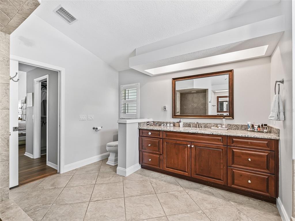 5714 Northwest 80th Ave Road Ocala, FL 34482 - Photo 22 of 39 a spacious bathroom with a granite countertop sink and a mirror