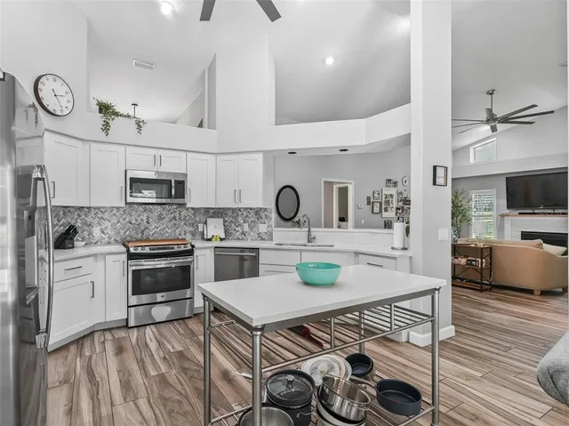 a kitchen with a table chairs refrigerator and cabinets