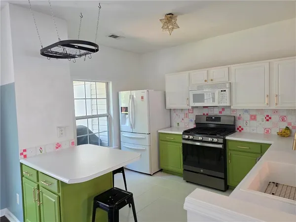 a kitchen with a stove a refrigerator and a dining table