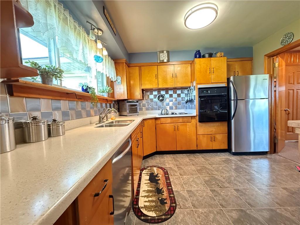 3344 Perry Highway Hadley, PA 16130 - Photo 34 of 50 a kitchen with stainless steel appliances granite countertop a sink a stove and a refrigerator