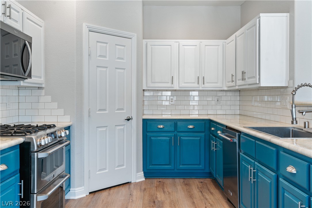 1328 Spice Ridge Court Henderson, NV 89012 - Photo 12 of 51 This contemporary kitchen features striking blue lower cabinets and pristine white upper cabinetry.