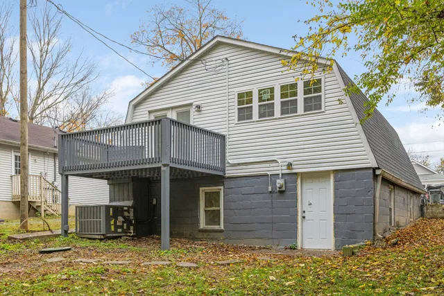 a view of a house with a wooden deck and a yard