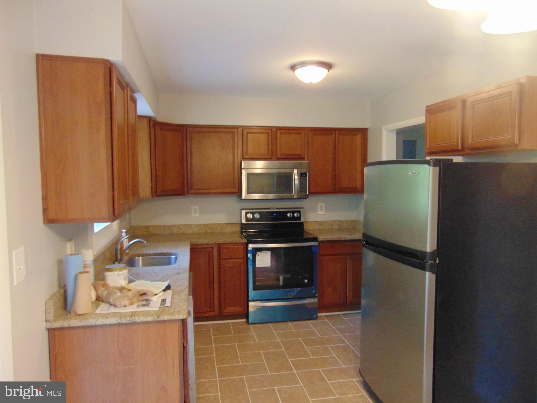 3706 Altondale Road Reisterstown, MD 21136 - Photo 3 of 27 a kitchen with stainless steel appliances granite countertop a refrigerator stove and microwave