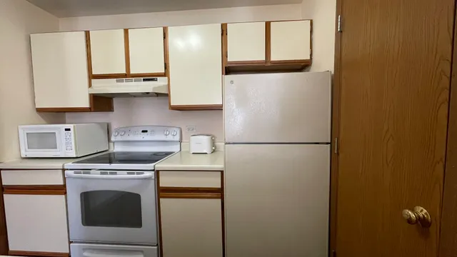 a kitchen with a refrigerator sink stove and cabinets